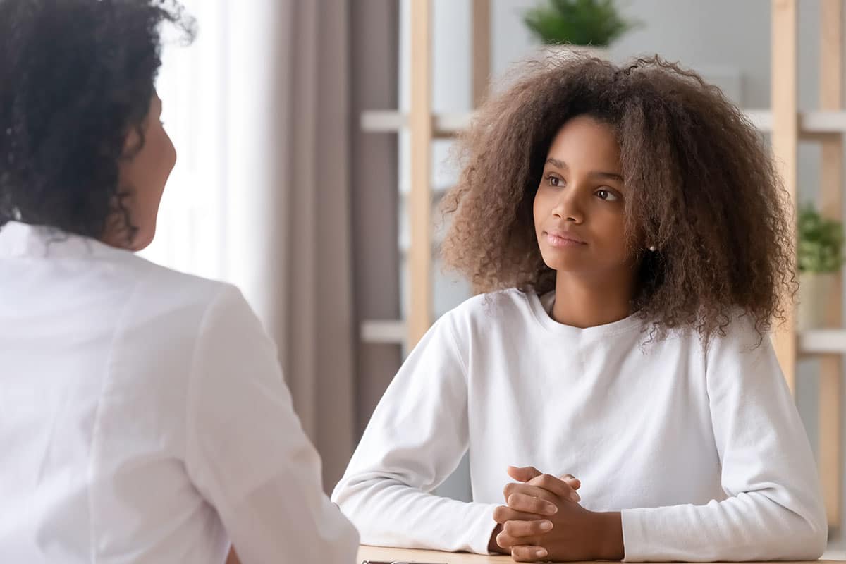 Young teenager speaking with health professional during assessment