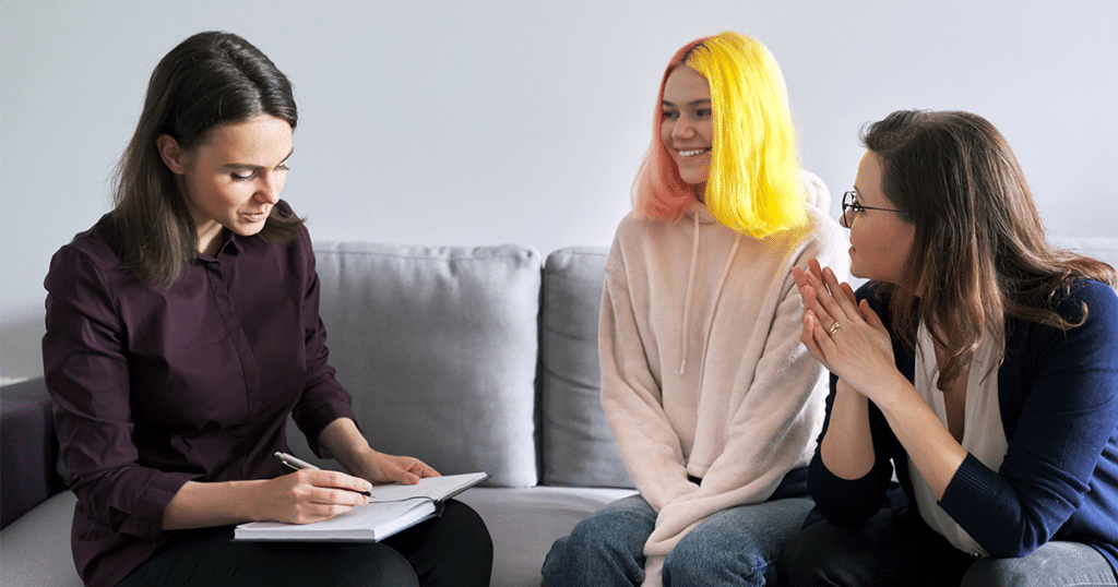 Teen smiling and talking to a counselor.