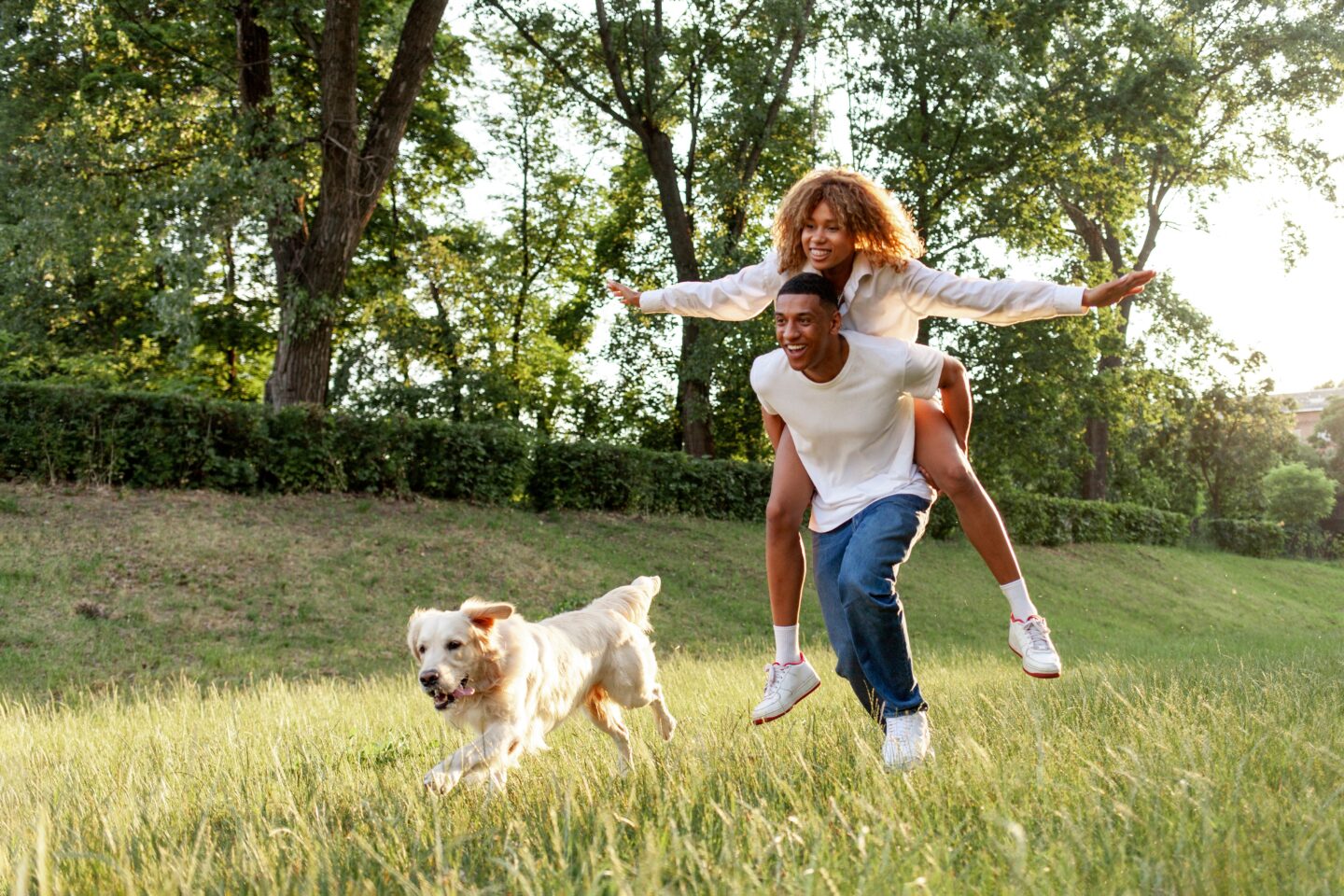 Young couple running with dog outside